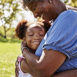 Close Up Of Granddaughter Hugging Grandmother In Park