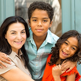 Hispnaic mother laughing and talking with her children. Portrait of a happy mixed race family.