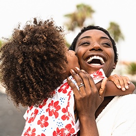 Happy African family on the beach during summer holidays - Afro American people having fun on vacation time - Parents love unity and travel lifestyle concept