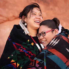 Cheerful navajo sisters hugging