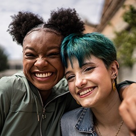 Portrait of friends embracing in the street