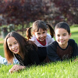 Mixture 3 cute children of diverse nationalities outdoors
