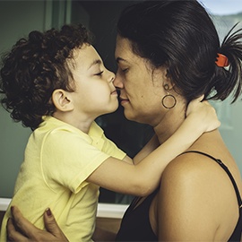 Mother and son embracing and kissing with love.