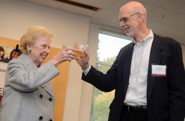 Joan Poliak disfruta de un brindis con sidra de manzana espumosa junto al administrador emérito Bob Watt.